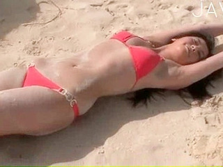 Sinfully horny Japanese babe fucks the sand on a Tokyo beach